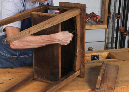 man removing top from wooden table
